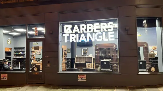 The Barbers Triangle shopfront window at night