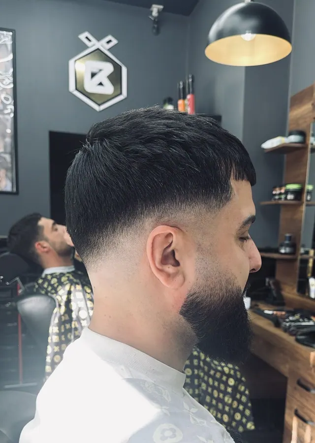 A textured crop with a skin fade and a full beard